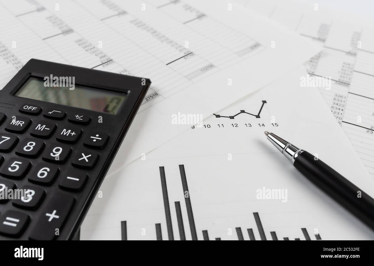 bookkeeping and accounting business concept, calculator and pen on data sheets and printed charts Stock Photo