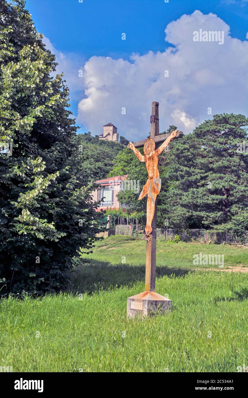 A symbol of the crucifixion of Jesus on a pillar and an old medieval fortress in the background. Stock Photo