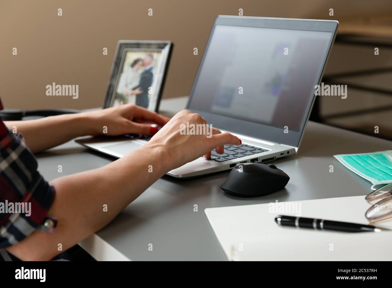 Young women working from home. Sitting in attic with laptop near roof window. New normal concept Stock Photo
