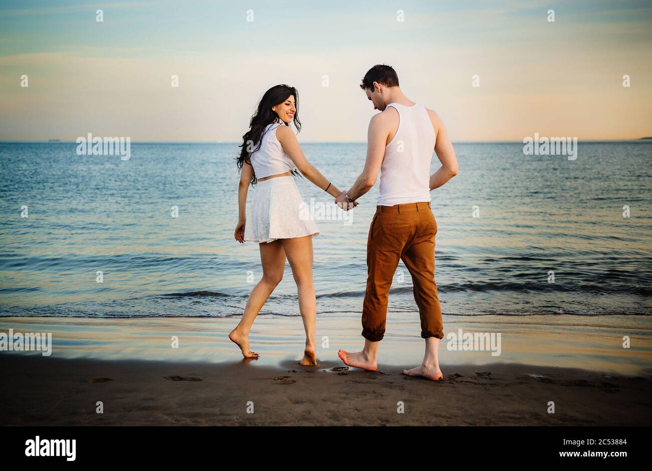 young couple walking on the beach Stock Photo
