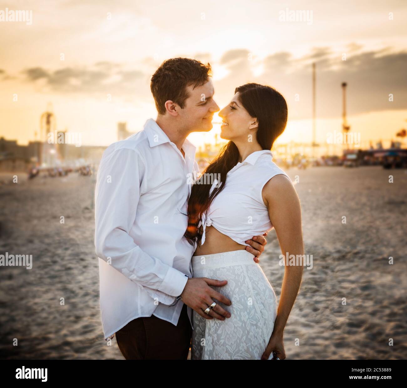 young couple on the beach at sunset Stock Photo