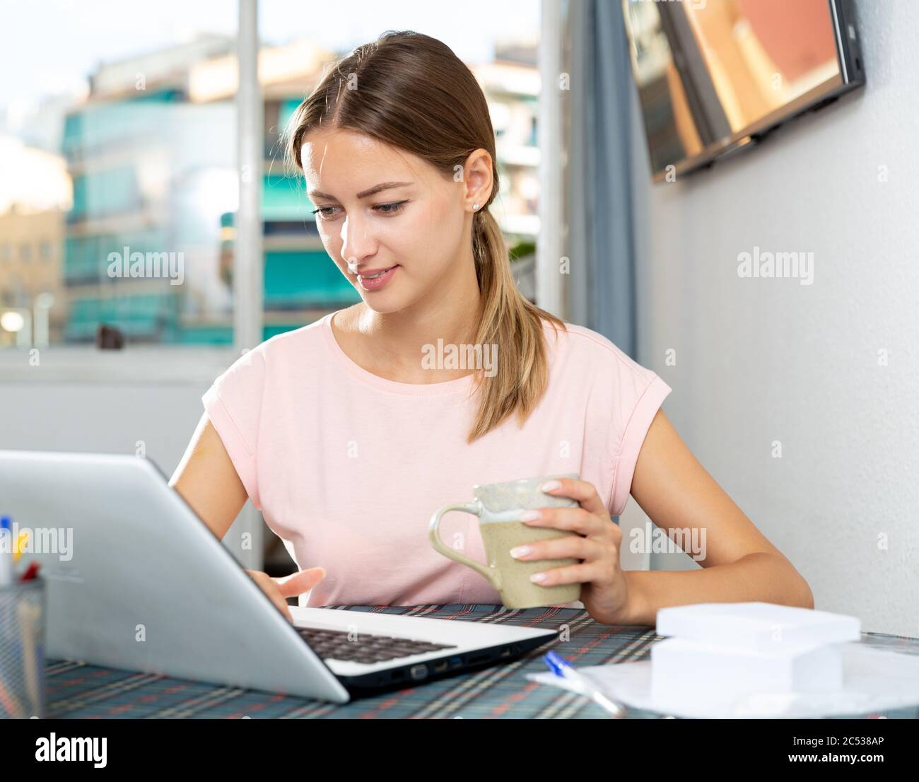 Positive young female surfing in Internet using laptop at home Stock ...