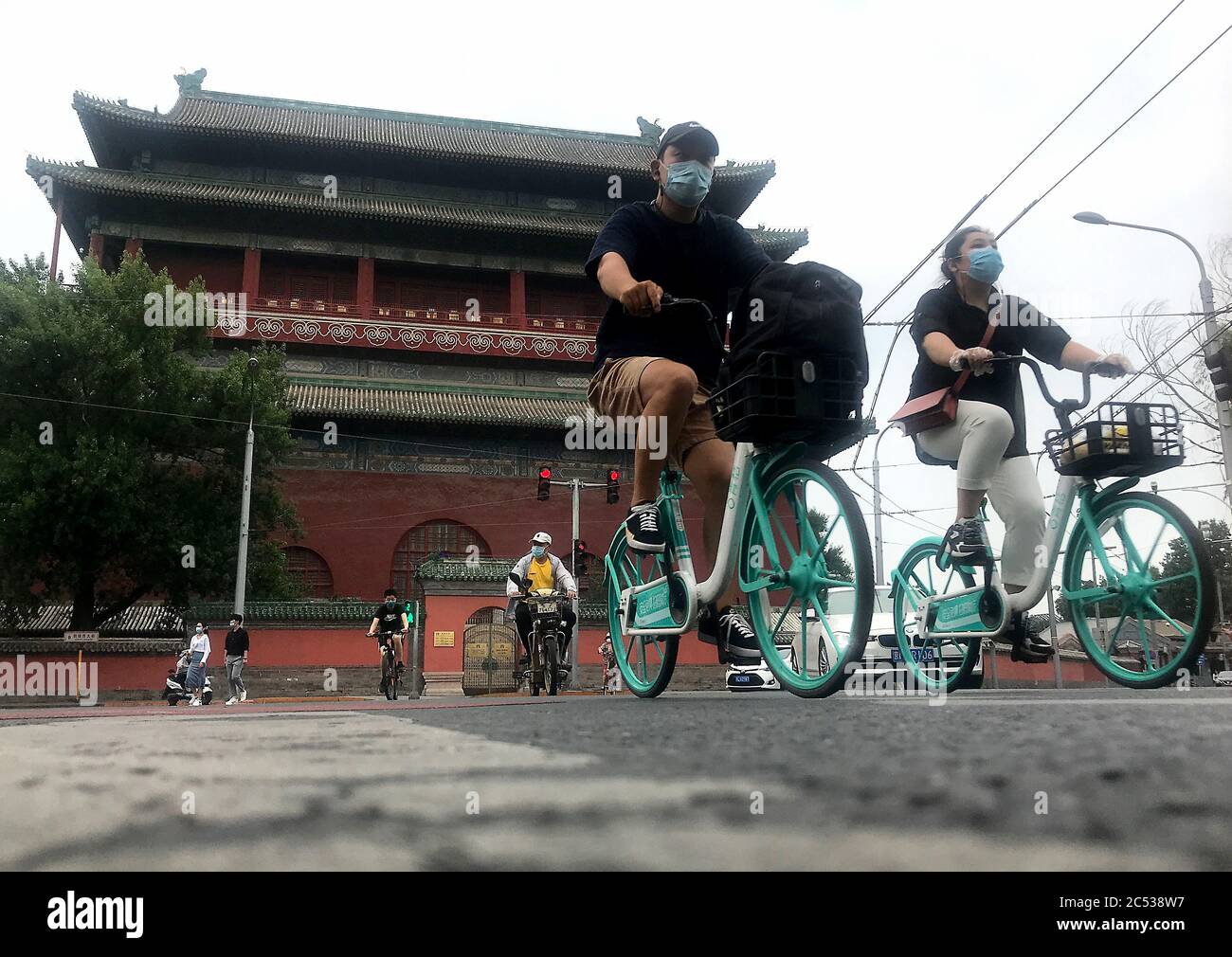 Beijing, China. 30th June, 2020. Chinese wear protective face masks as they bicycle through a historic area normally bustling with tourists in Beijing on Tuesday, June 30, 2020. China's capital remains under a soft lockdown due to new infections detected at a public market. Photo by Stephen Shaver/UPI Credit: UPI/Alamy Live News Stock Photo