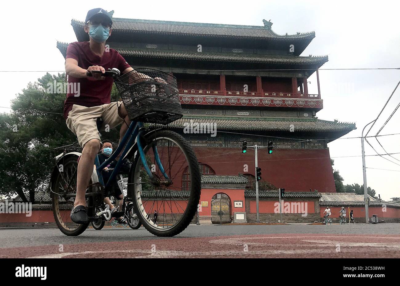 Beijing, China. 30th June, 2020. Chinese wear protective face masks as they bicycle through a historic area normally bustling with tourists in Beijing on Tuesday, June 30, 2020. China's capital remains under a soft lockdown due to new infections detected at a public market. Photo by Stephen Shaver/UPI Credit: UPI/Alamy Live News Stock Photo