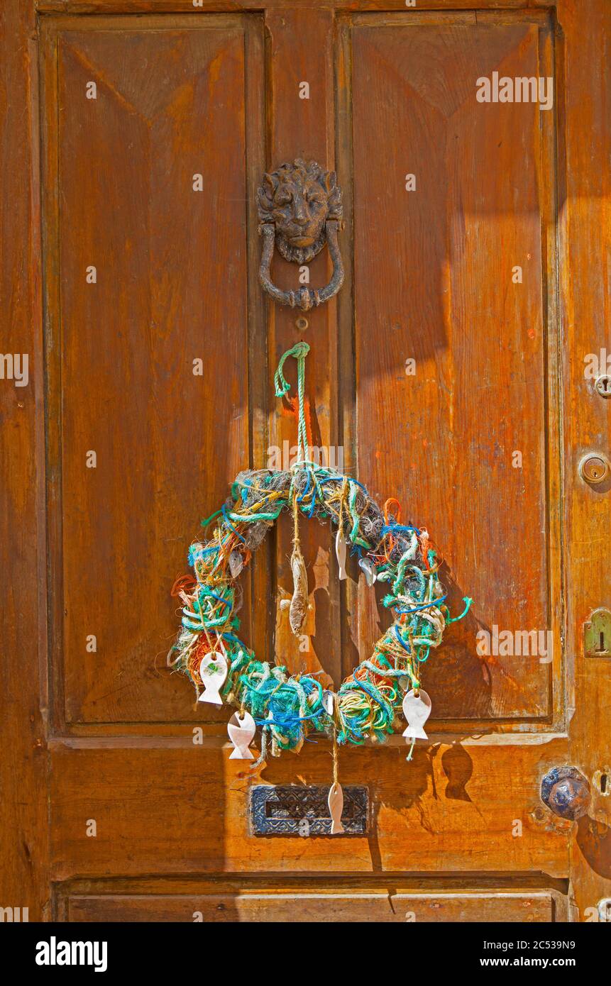 Wreath made up of old fishing line and rope on a wooden door in Appledore, Devon. Stock Photo