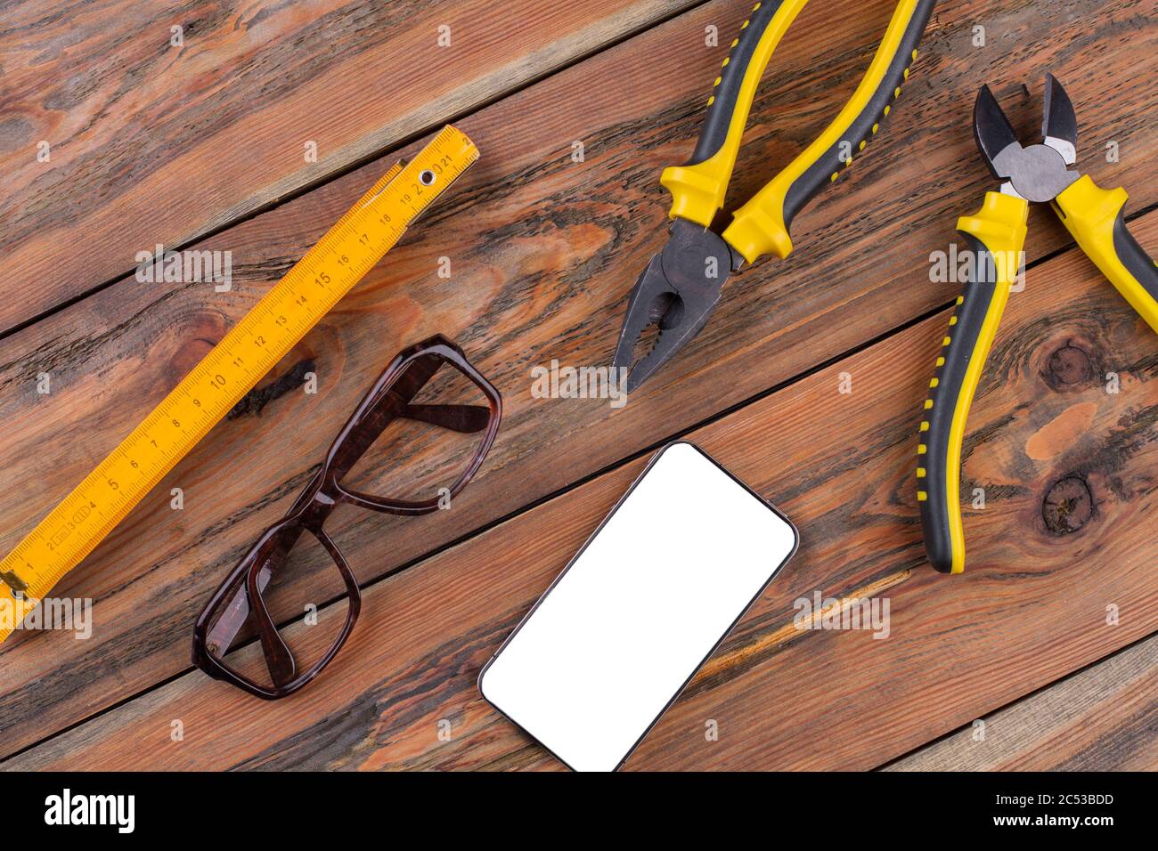 Construction hand tools on the working desk - pliers, nippers, ruler. Stock Photo