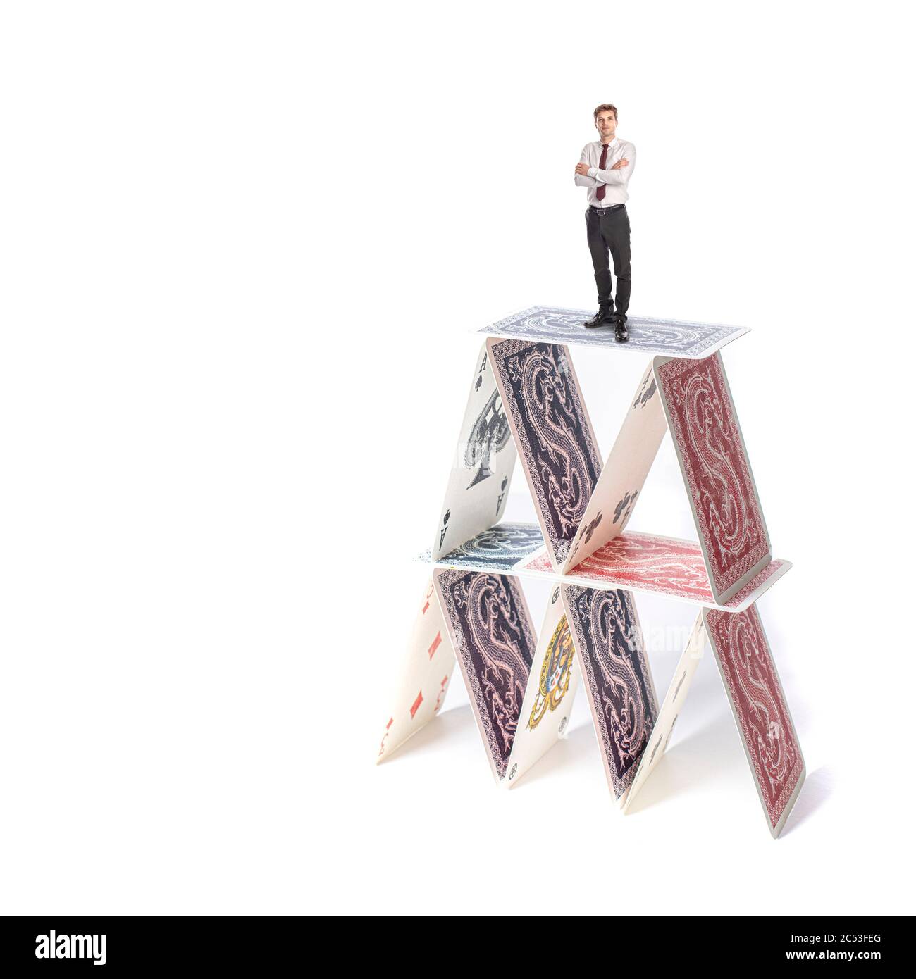 house of cards with a businessman with arms crossed over it. concept of uncertainty, danger. Stock Photo
