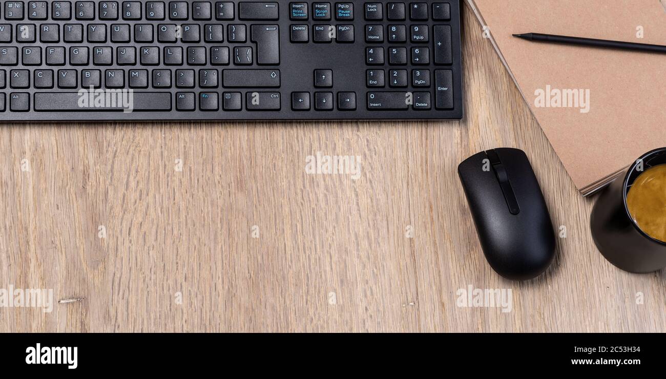 office table with notebook, computer keyboard, mouse, cup of coffee,  copy space Stock Photo
