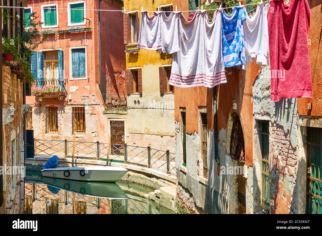Colorful view of narrow venetian canal with drying linen outside, Venice, Italy - Italian urban landscape Stock Photo