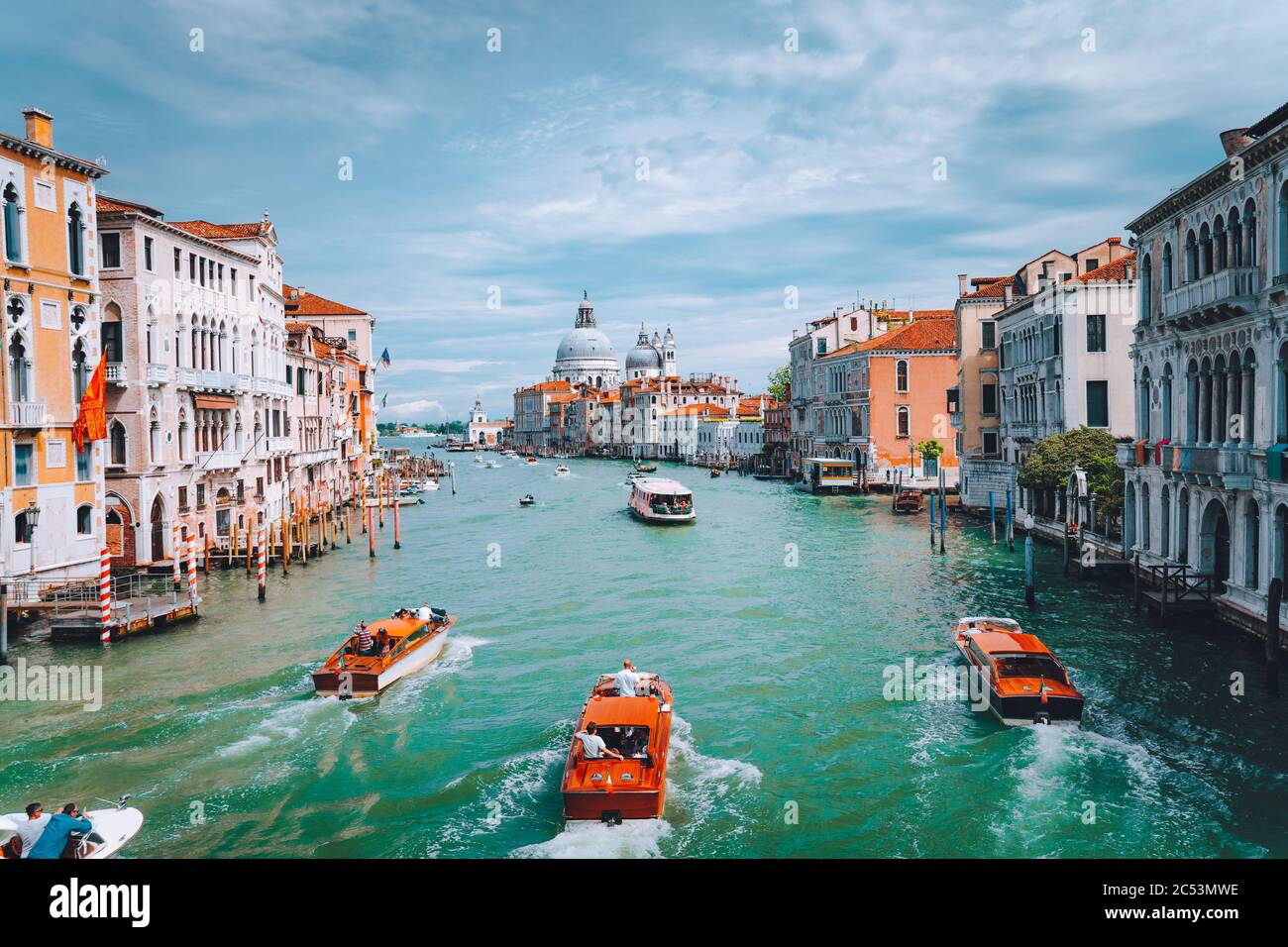 Venice, Italy. Tourist boats in Grand Canal with Basilica Santa Maria della Salute view in background. Stock Photo