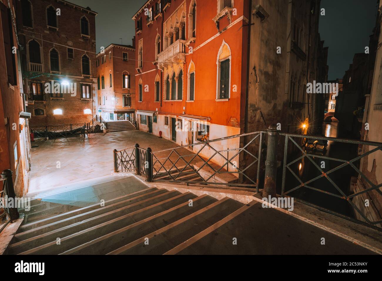 Gothic quarter with old red brick wall houses at night. Empty alleyways and bridge stairs in Venice, Italy. Stock Photo