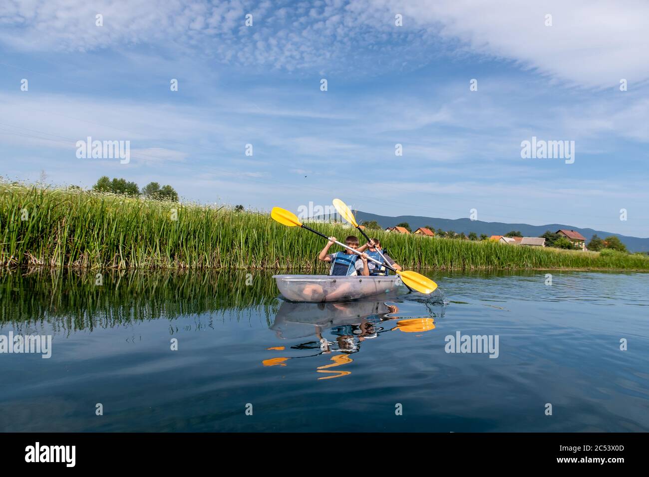 Young people enjoying a kayacking experience on the calm clear waters of the river Gacka, Otocac, Lika, Croatia Stock Photo