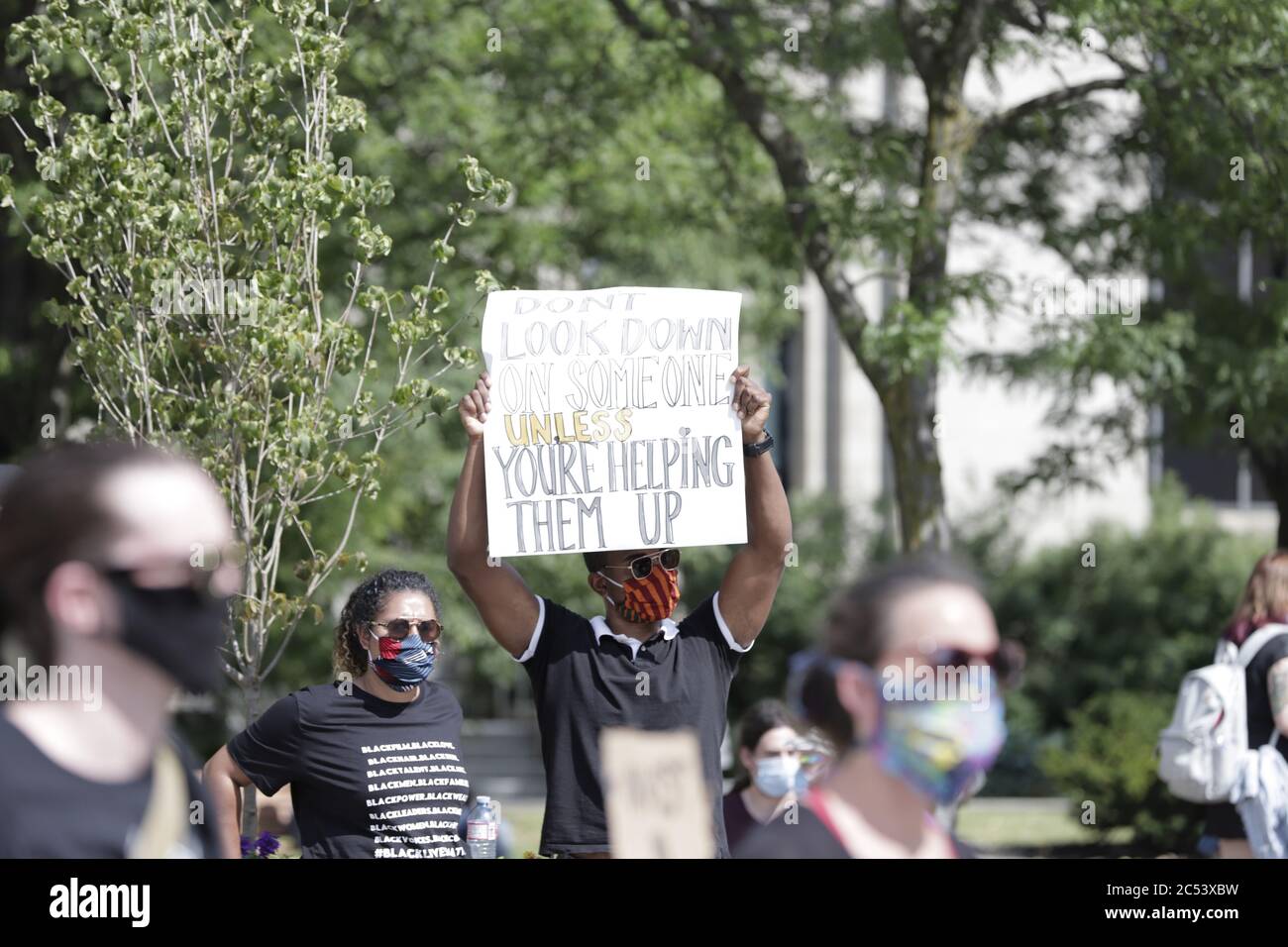 A man seen in the midst of the crowd holding up a placard in a peaceful Anti-Racism protest at the Hamilton City Hall Stock Photo