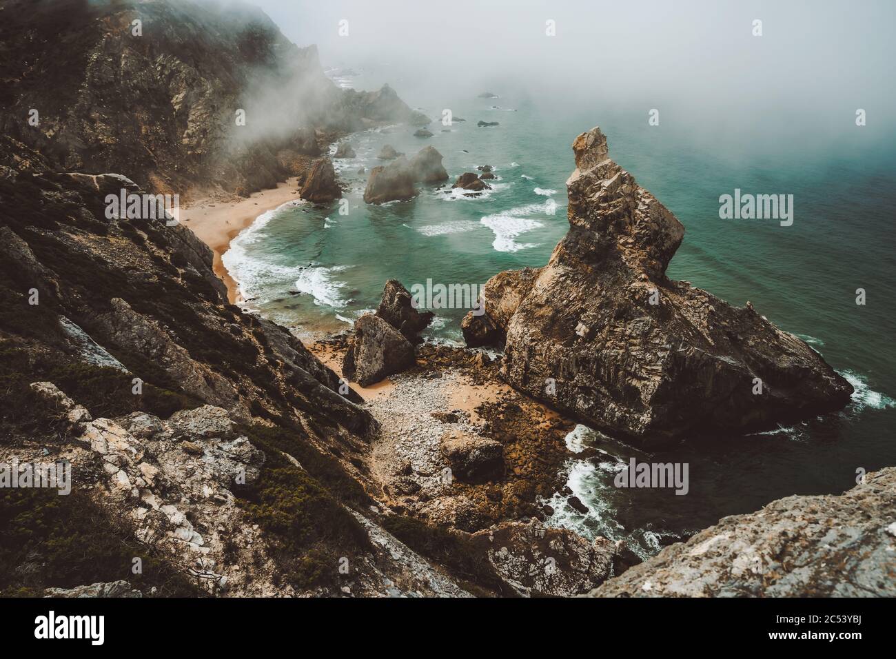 Sentra, Portugal. Moody foggy weather at Praia da Ursa beach on morning. Rough Atlantic Ocean. Stock Photo