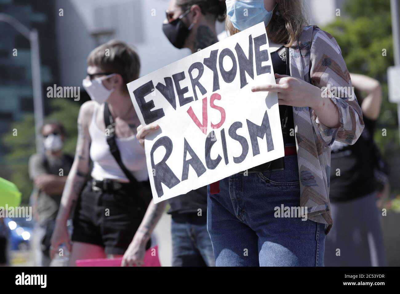 A young woman seen holding up a placard saying Everyone Against Racism, during a Black Lives Matter protest at the Hamilton City Hall Stock Photo