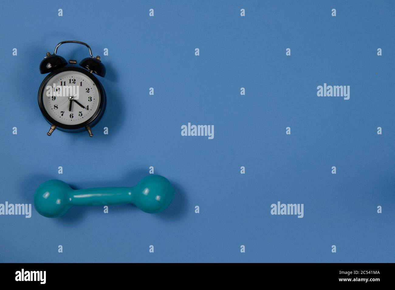 alarm clock and exercise weight with space for writing text Stock Photo