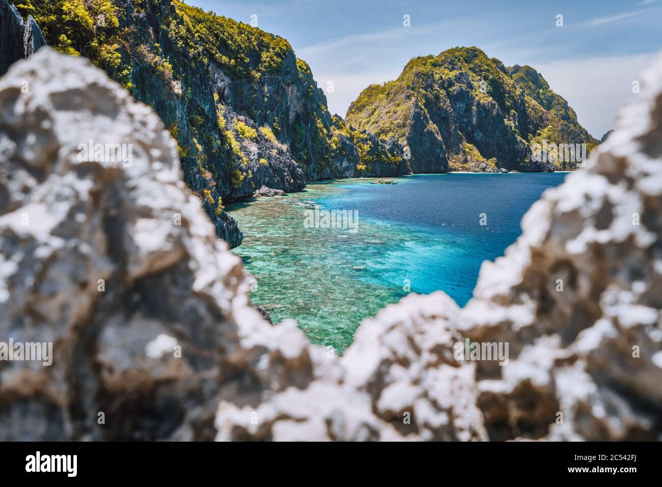 El Nido, Palawan, Philippines. Matinloc island and tapiutan strait framed by limestone sharp rocks in foreground. Bacuit Archipelago. Stock Photo