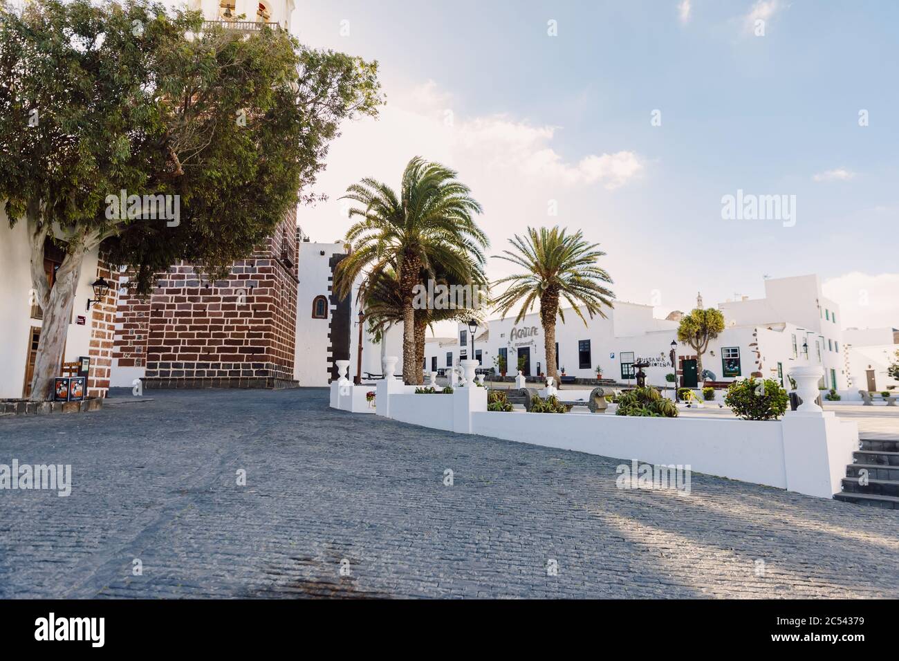 Lanzarote, Spain - April 04, 2020. The old architecture of city of Teguise. Church Iglesia de Nuestra Senora de Guadalupe and palms Stock Photo