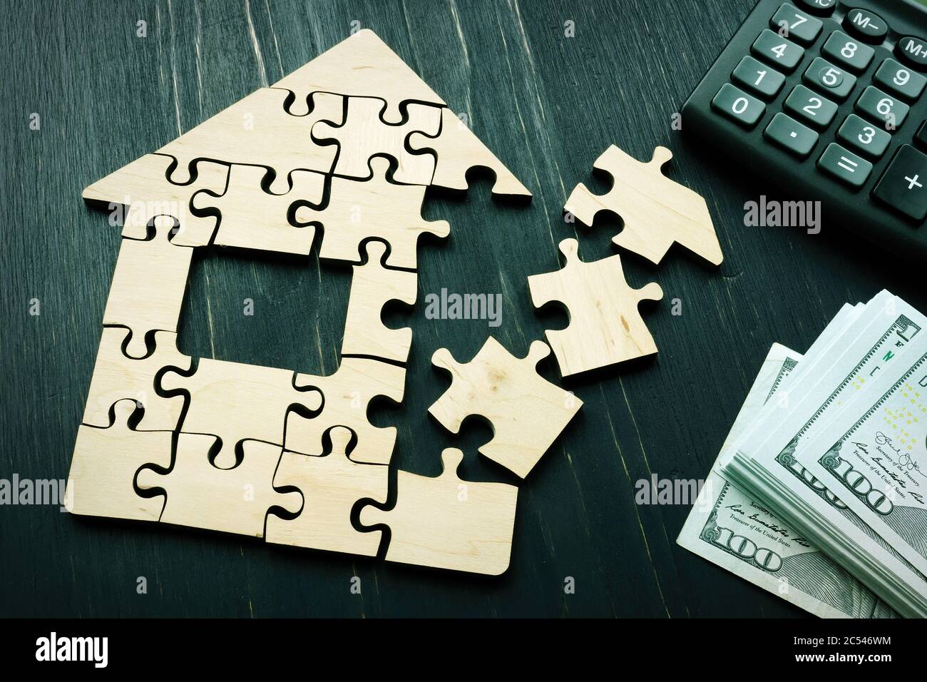Mortgage concept. House shape from puzzle pieces and money. Stock Photo
