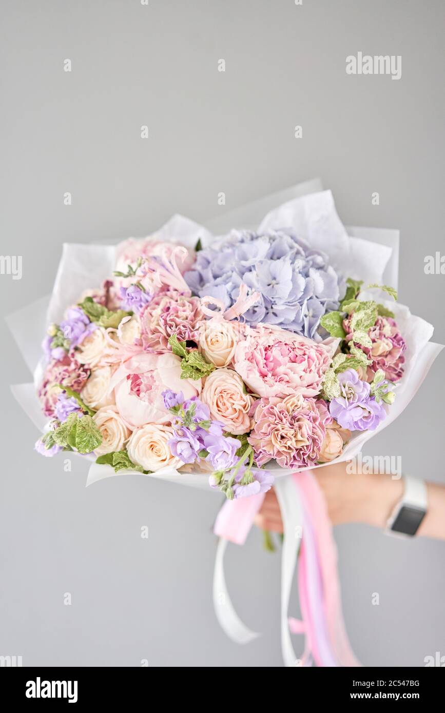 Beautiful bouquet of mixed flowers in woman hand. Floral shop concept . Handsome fresh bouquet. Flowers delivery. Stock Photo