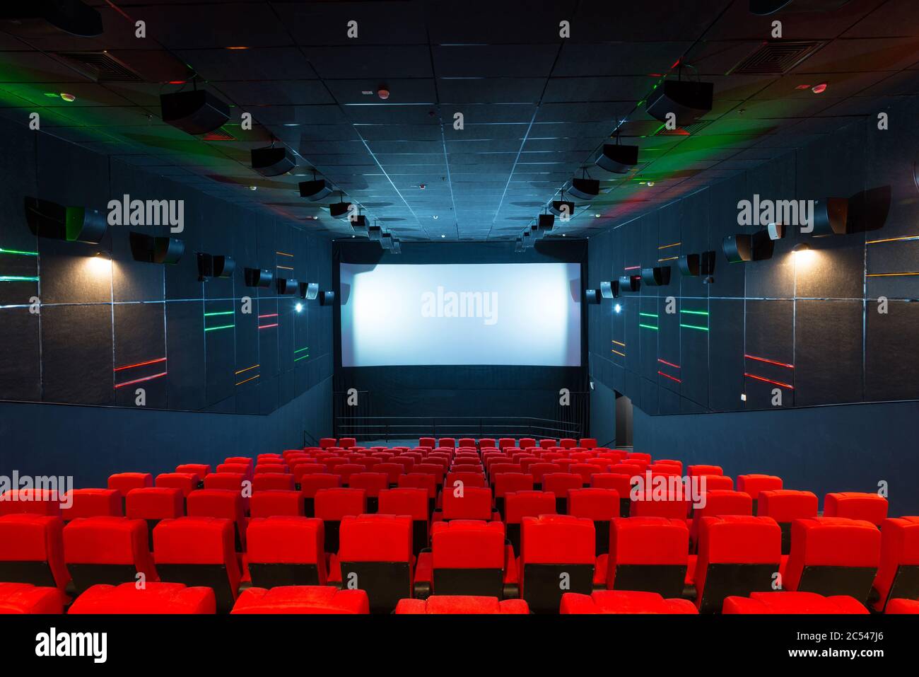 Panoramic view of an empty luxury cinema hall with a screen. Contemporary cinema auditorium design with LED light. Panorama of the modern comfortable Stock Photo