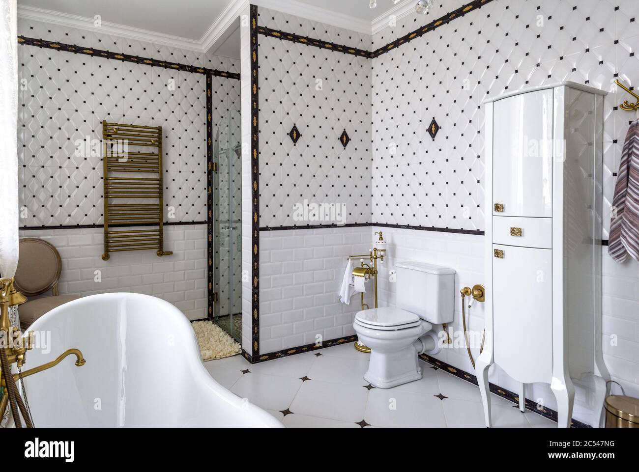 Moscow - Aug 24, 2019: Interior of bathroom in hotel or residential house. Interior design of restroom in classic style with white tiles. Panoramic vi Stock Photo