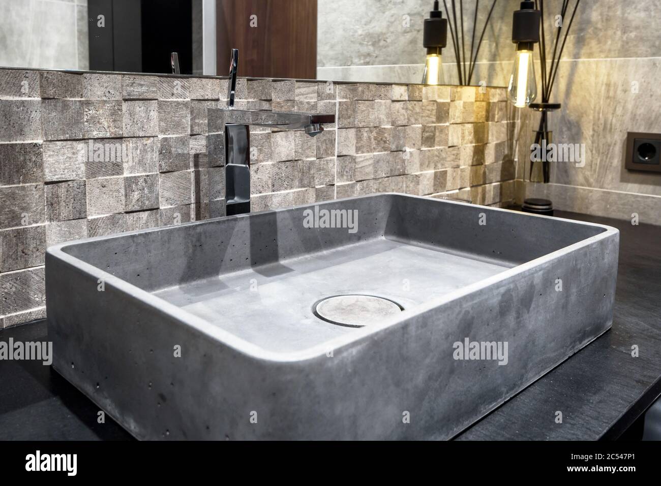 Moscow - March 25, 2018: Modern stylish restroom in a hotel or residential house. Interior design with concrete sink in the bathroom. Contemporary min Stock Photo