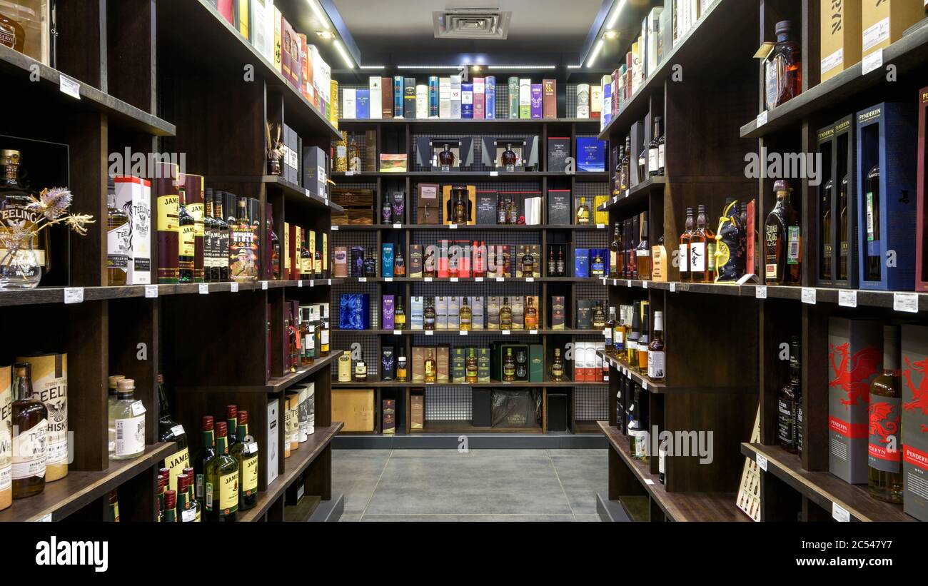 Moscow – Oct 6, 2019: Panoramic view of wine shop interior. Various wine bottles sale on wooden shelves in supermarket. Inside the luxury liquor store Stock Photo