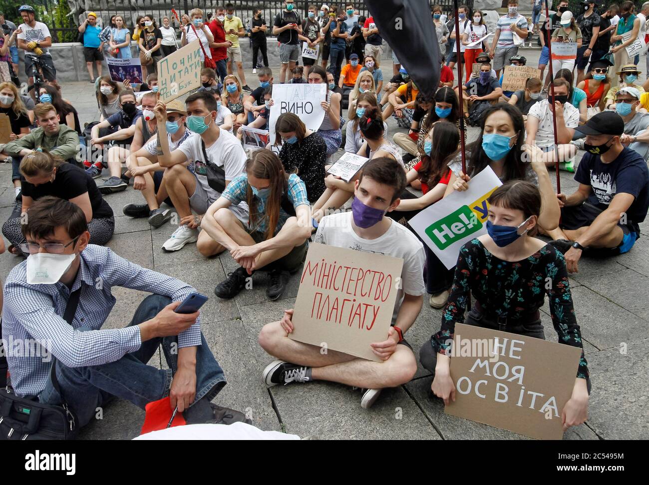 Students sit down while displaying placards outside the Presidential Administration in Kiev.Students and scientists held their sedentary protest against the newly appointed acting Minister of Education and Science Serhiy Shkarlet demanding his resignation because he was a member of the Party of Regions and supported former president Viktor Yanukovych, reported by media. Stock Photo