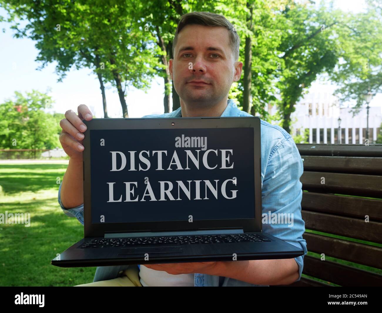 Distance learning concept. Student shows a laptop with the inscription. Stock Photo