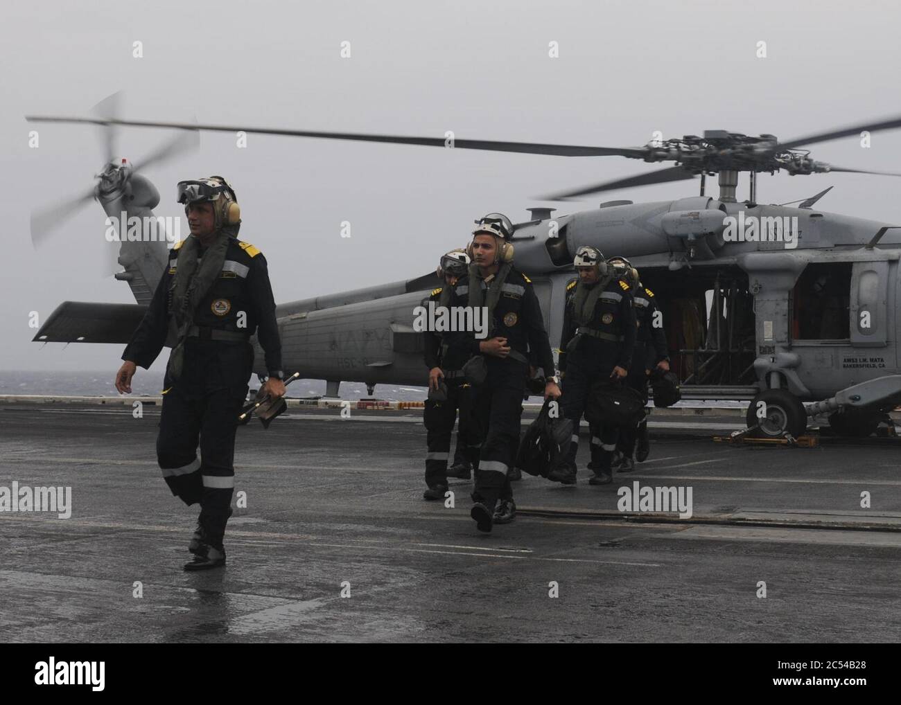 Indian Navy Rear Admiral Biswajit Dasgupta, flag officer commanding eastern fleet, transits the flight deck of the aircraft carrier USS Nimitz (CVN 68) after arriving aboard via an MH-60R Seahawk helicopter. Stock Photo