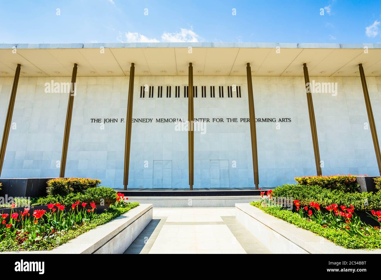 Front view of the Kennedy Center in Washington, D.C. flanked by two flower beds full of red tulips on a sunny Spring day Stock Photo