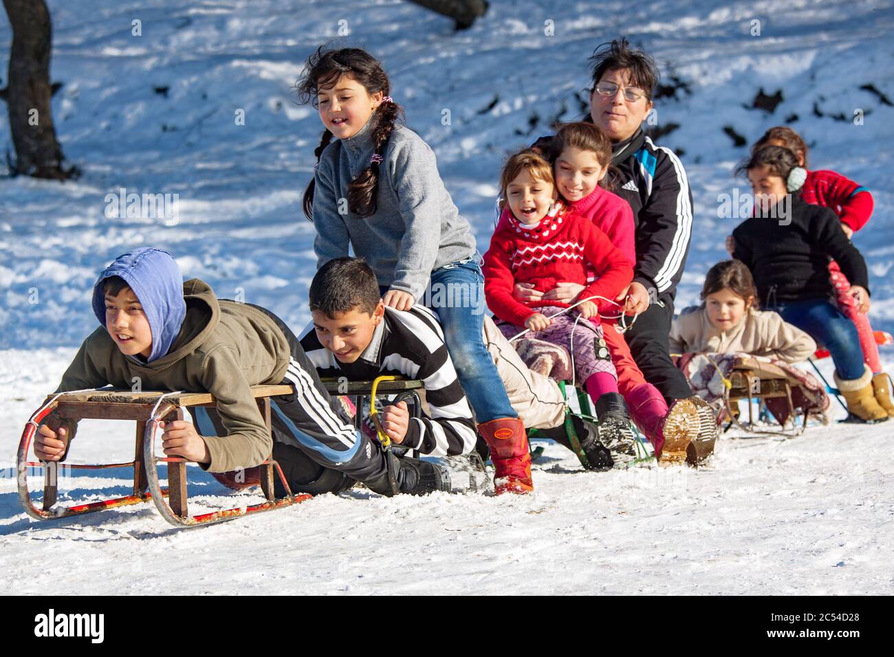 FAGET, CLUJ COUNTY, ROMANIA - FEBRUARY.04.2014: Children from a socially disadvantaged community taken on a vacation trip on a slope to go sledding Stock Photo