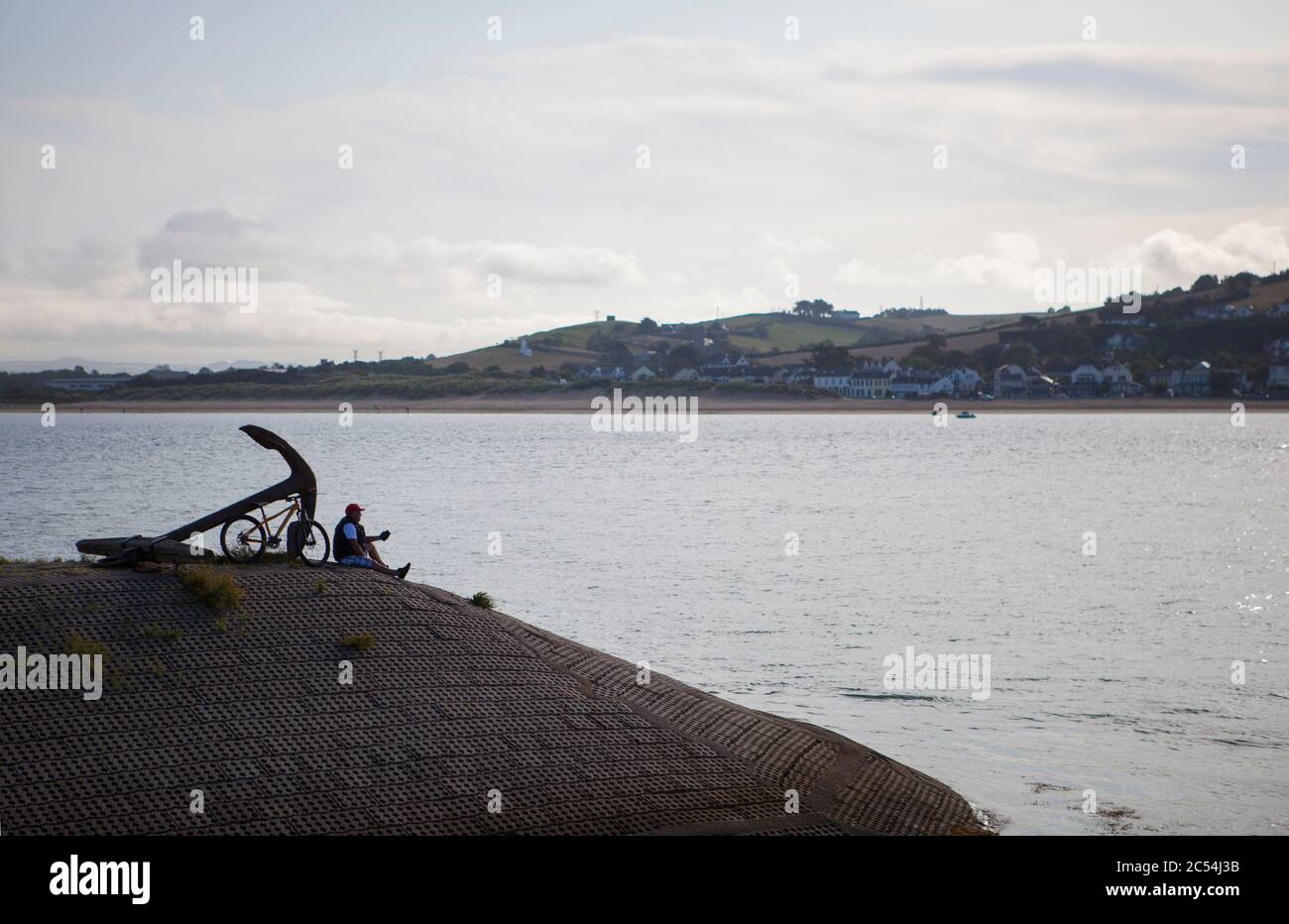 Silhouette of a man relaxing by the waters of the river Torridge, at Appledore, North Devon Stock Photo