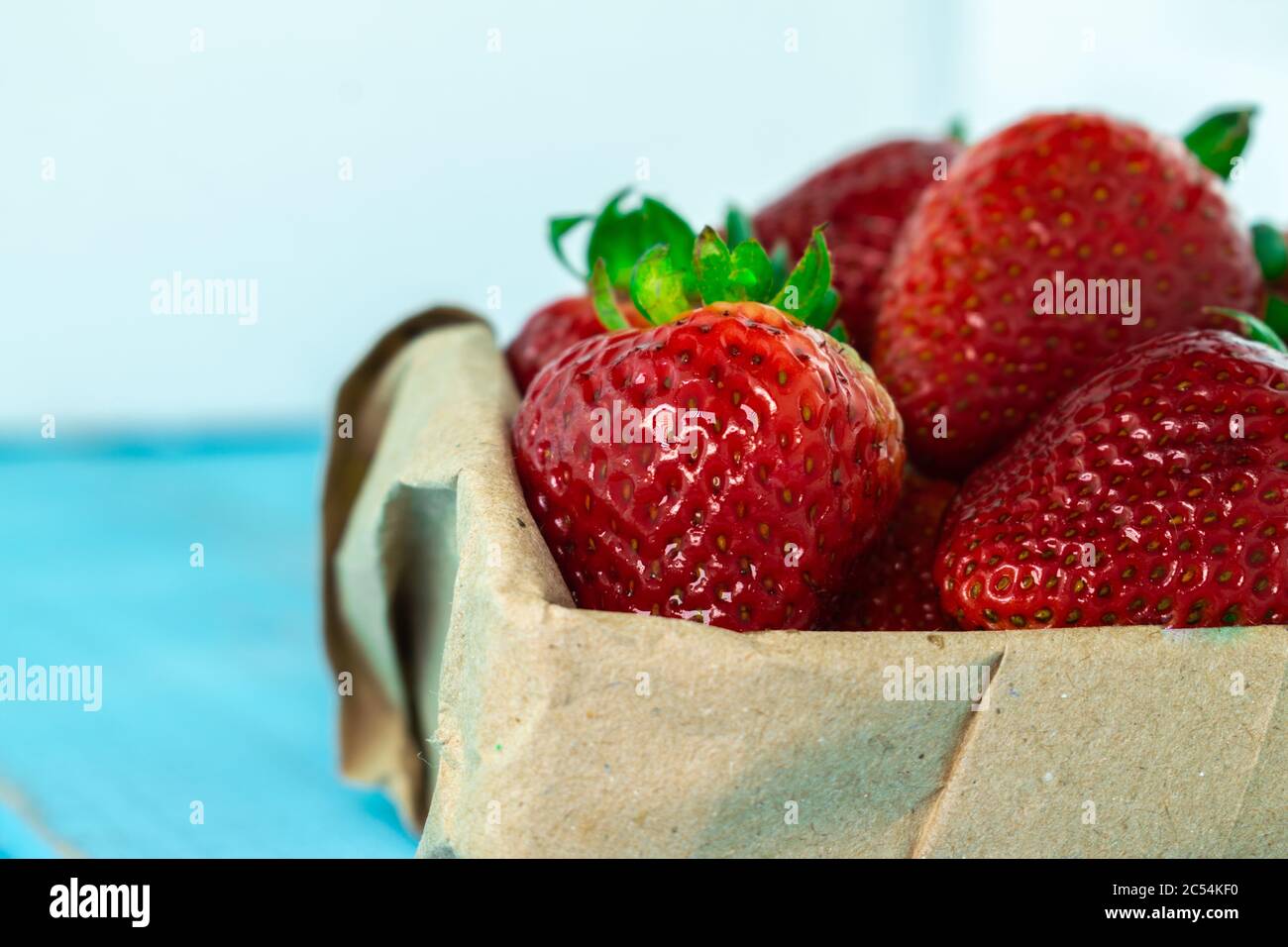 Closeup shot of fresh ripe strawberries in a box on a blurred ...