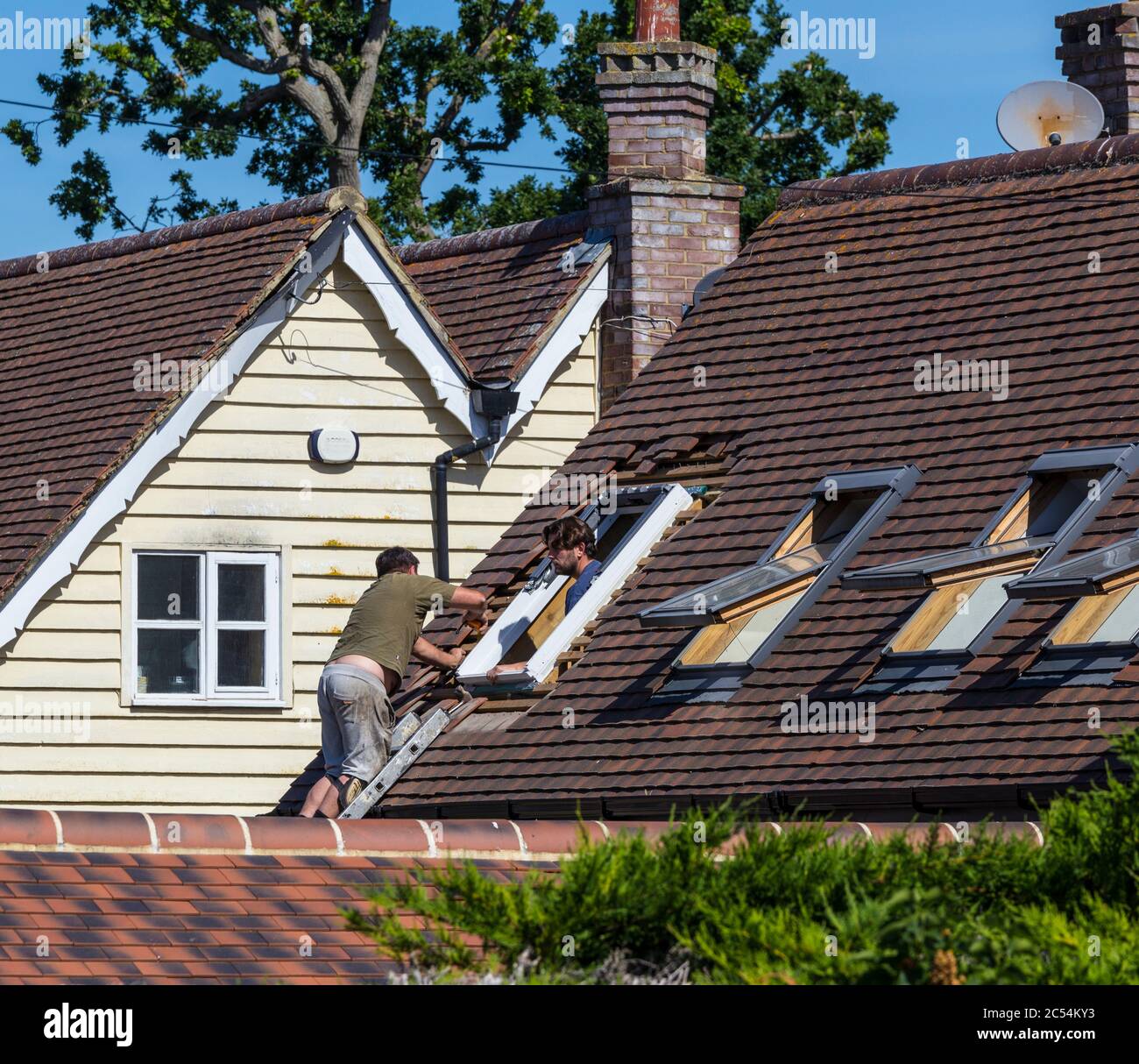 Builders repairing skylight window. Stock Photo