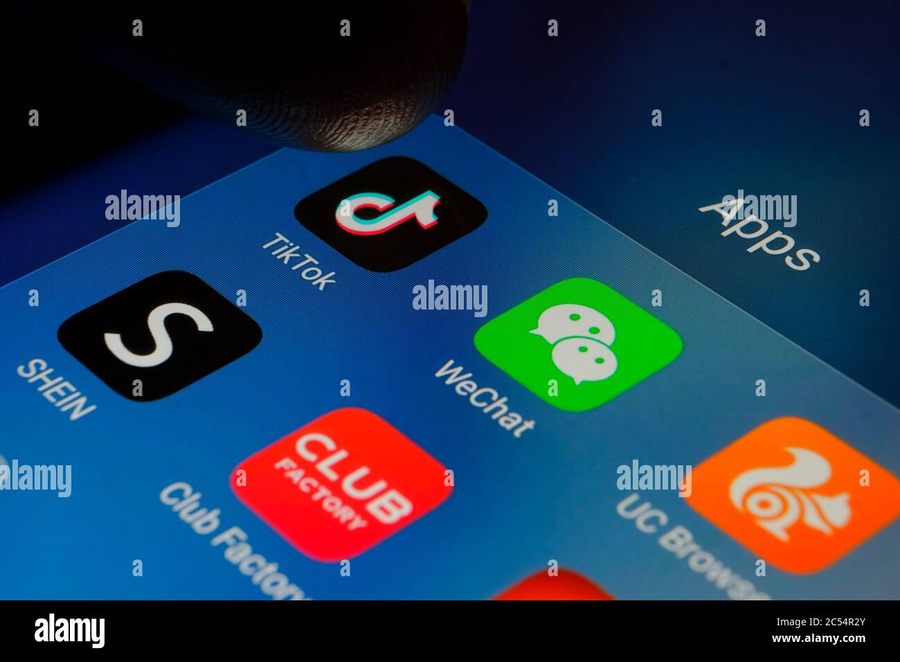 Finger pointing at TikTok app surrounded by chinese WeChat, Club Factory, Shien, UC Browser apps. Photo of Chinese apps that were banned in India Stock Photo