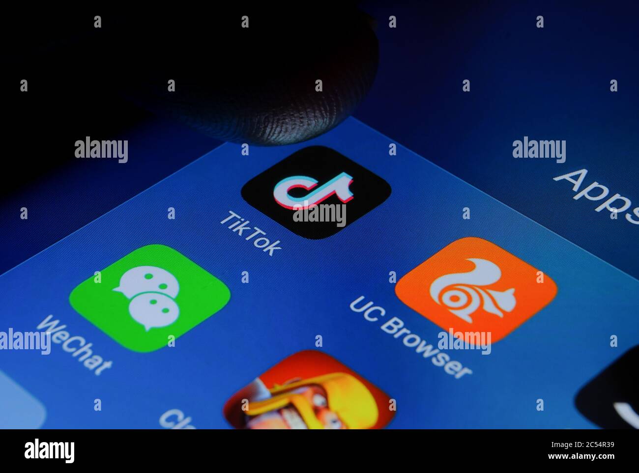 TikTok, WeChat, UC Browser, Clash of Clans apps and finger pointing at them. Photo of Chinese apps that were banned in India due to security concerns. Stock Photo