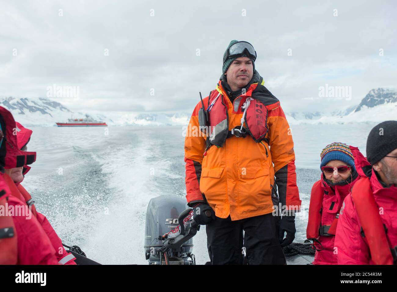 Expedition crew member driving a zodiac boat in Charlotte bay antarctica Stock Photo