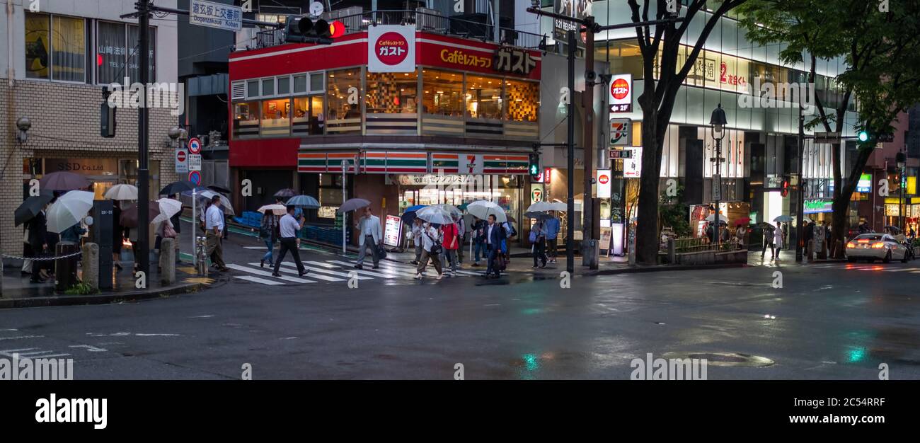 People with umbrella walking at Dogenzakue street sidewalk, Tokyo, Japan Stock Photo
