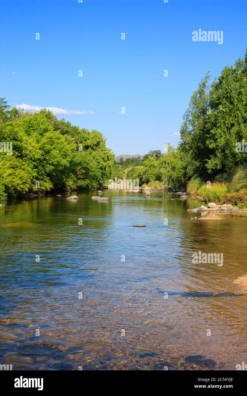 LOS REARTES, CORDOBA, ARGENTINA. Beautiful view of the river Rings, Cordoba on a spring afternoon. The blue sky over the calm river and clear water. S Stock Photo