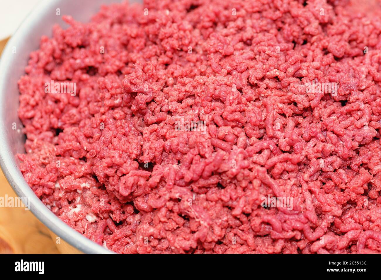 Advertising of fresh minced meat in minced meat close up. Minced meat.  Choppedl meat through manual meat grinder close-up. Copy space on the backgrou Stock Photo