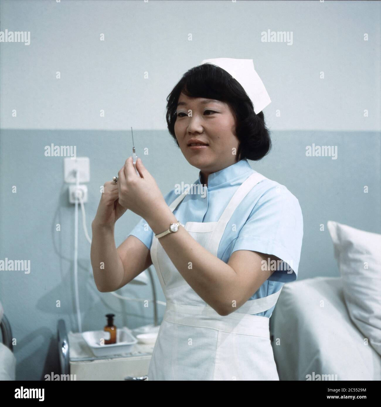 Chong Hi Kim bereitet als Krankenpflegerin eine Spritze vor in Der schwarze Doktor, Regie: Helmut Kissel, 1975. Chong Hi Kim as a nurse preparing an injection in Der schwarze Doktor, Director: Helmut Kissel 1975. Stock Photo