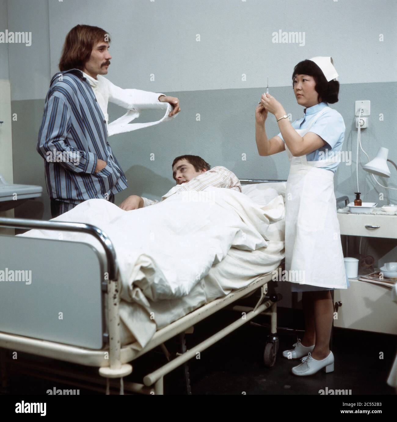 Chong Hi Kim als Krankenpflegerin mit Patienten in Der schwarze Doktor, Regie: Helmut Kissel, 1975. Chong Hi Kim as a nurse with patients in Der schwarze Doktor, Director: Helmut Kissel 1975. Stock Photo