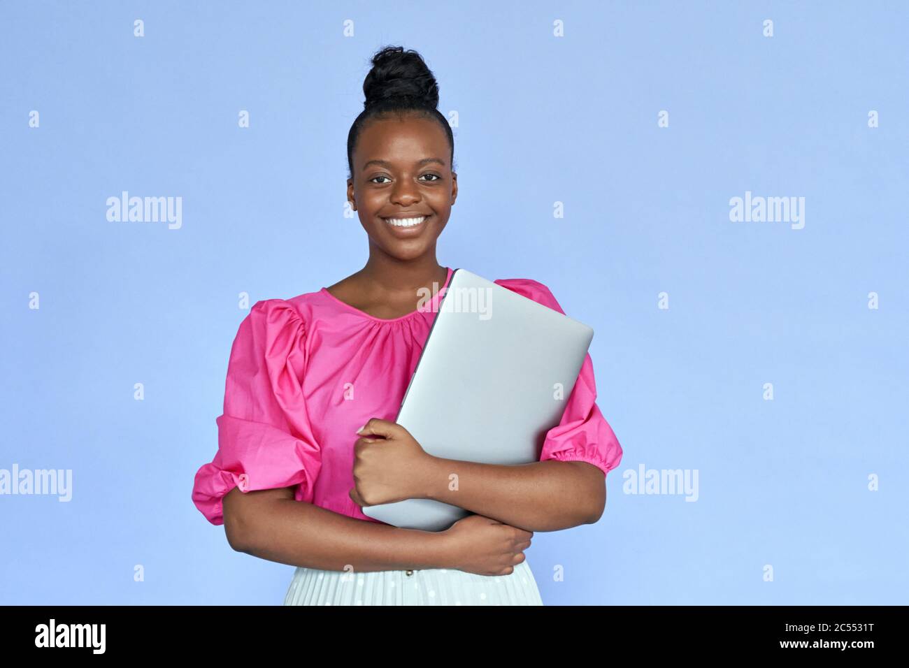 Smiling african woman student hold laptop look at camera on violet background. Stock Photo
