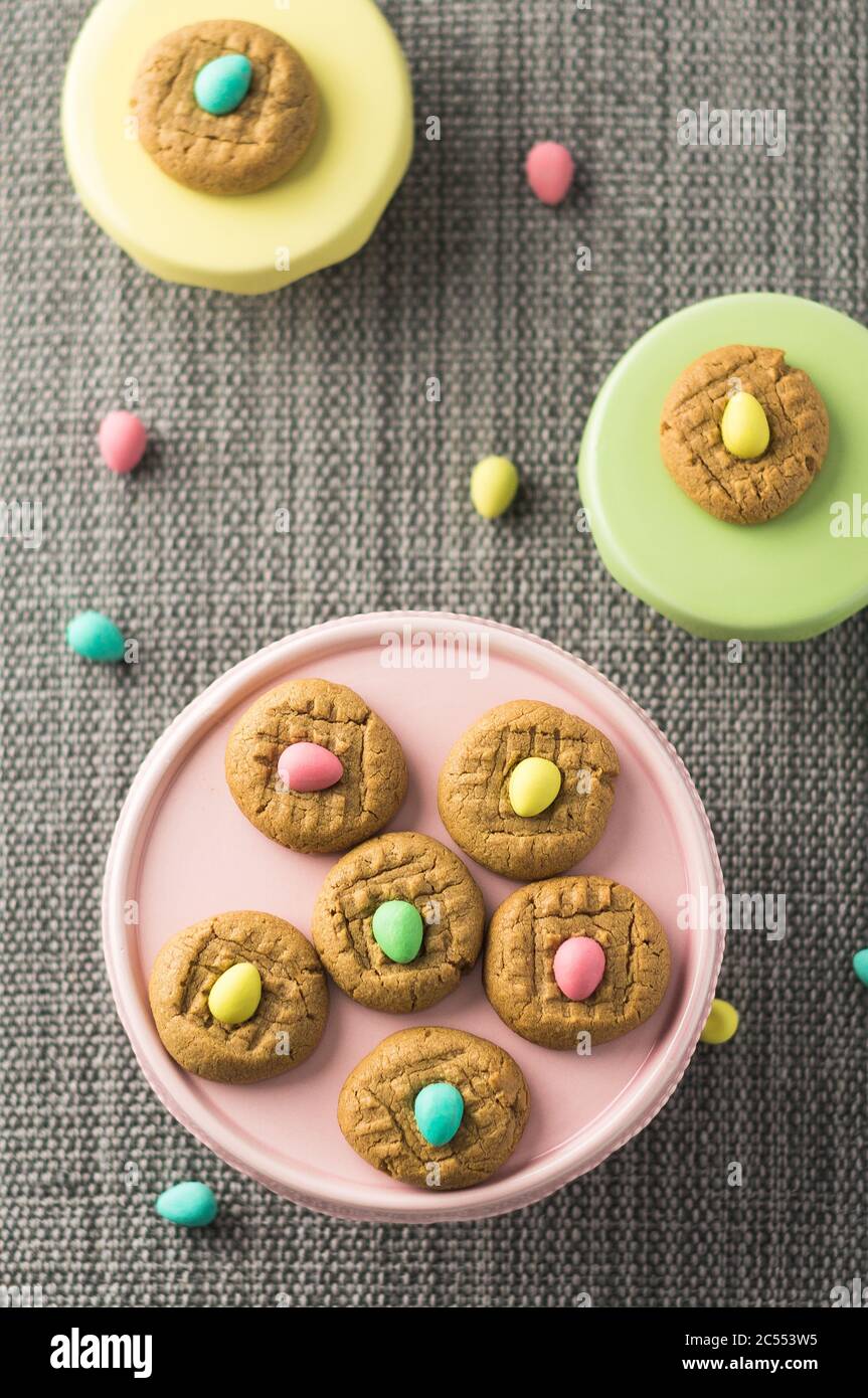 Easter cookies above flat top view. Homemade peanut butter cookies desserts with a Easter holiday twist! Chocolate easter eggs are added on top of eac Stock Photo