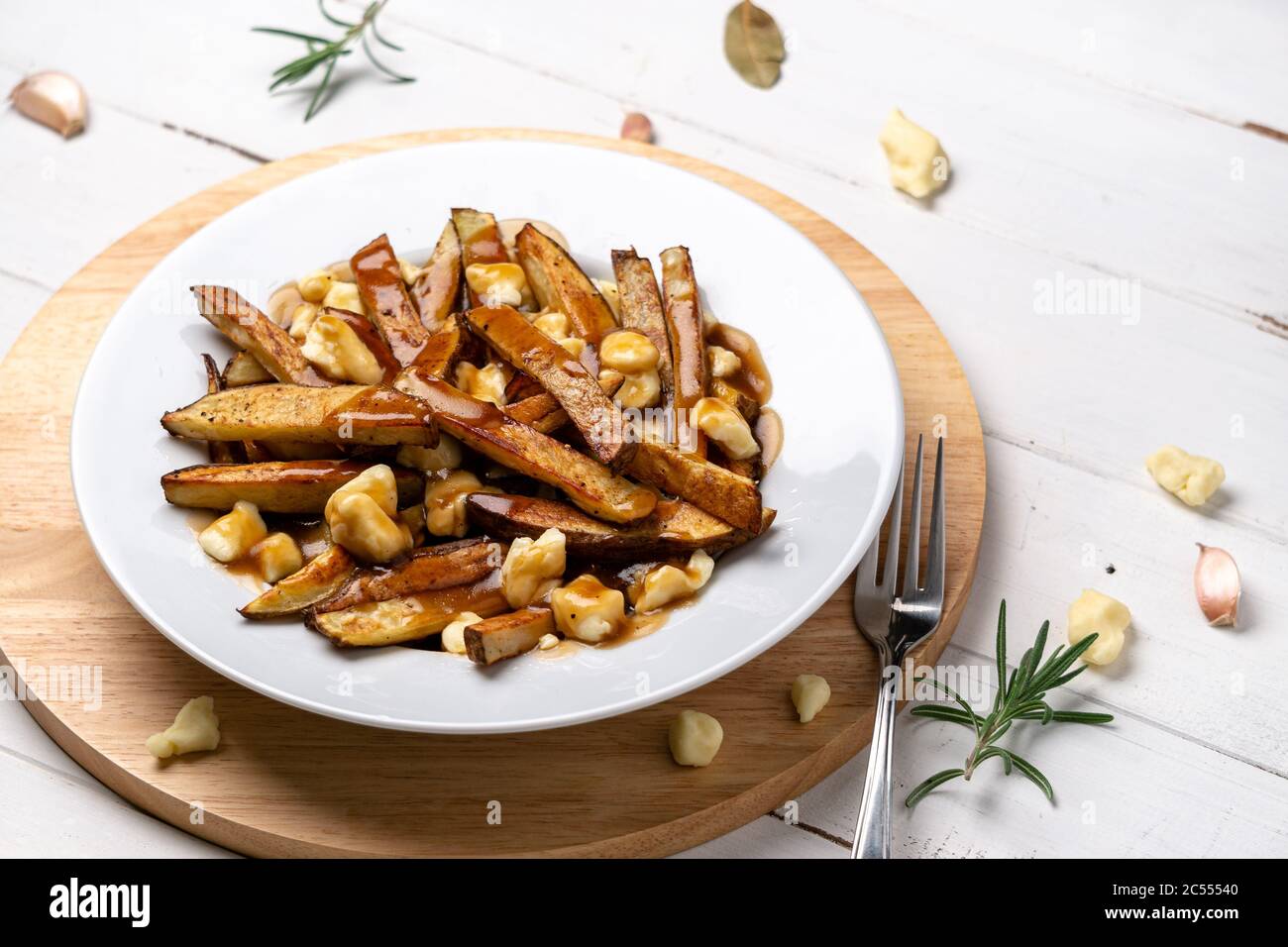Montreal Poutine gravy fries dish. A classic fast food cuisine dish from Quebec. This canadian comfort food is made with french fries mixed with tasty Stock Photo