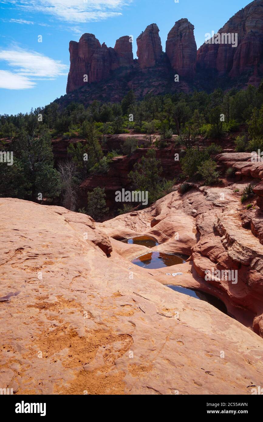 Three of Sedona's well known Seven Pools reflect the sandstone towers in the distance. Stock Photo