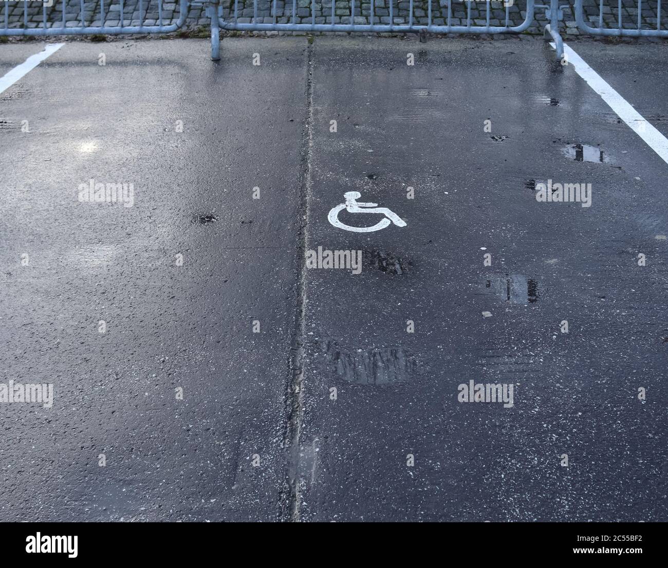 Parking lot with painted sign of wheelchair. Parking spaces for disabled customers. Stock Photo