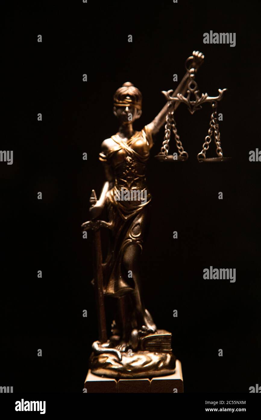 Vertical shot of lady justice bronze statue isolated on a black